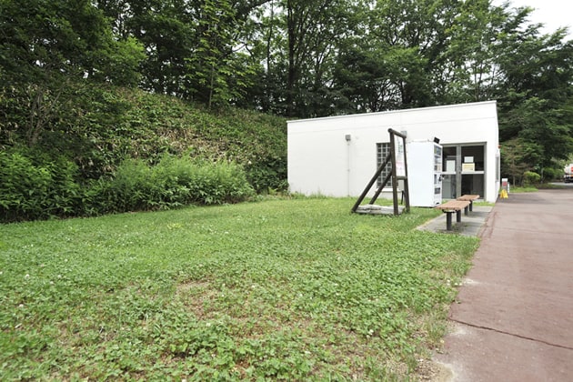建物の横には、緑地とベンチがあります。