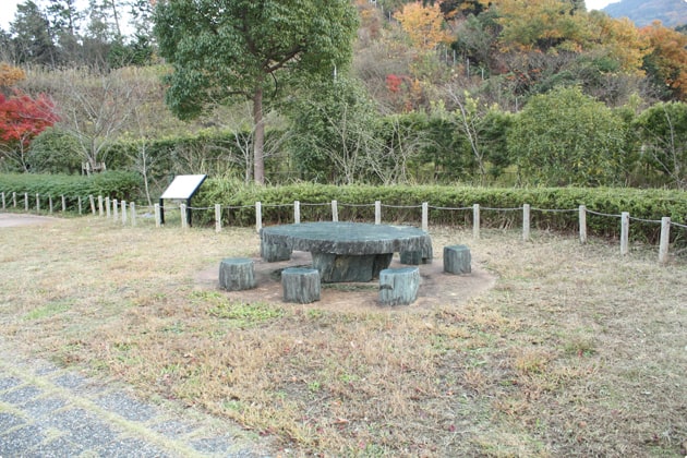 歩道の脇に石のテーブルとベンチが設置されています。