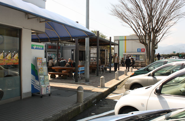 建物の横に屋根付きのテーブルとベンチがあります。