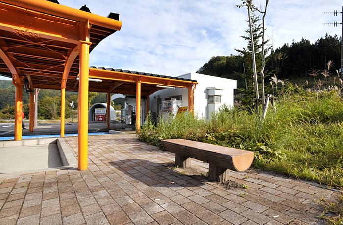 建物横にはベンチ、建物前には屋根付きスペースが少しありますよ。