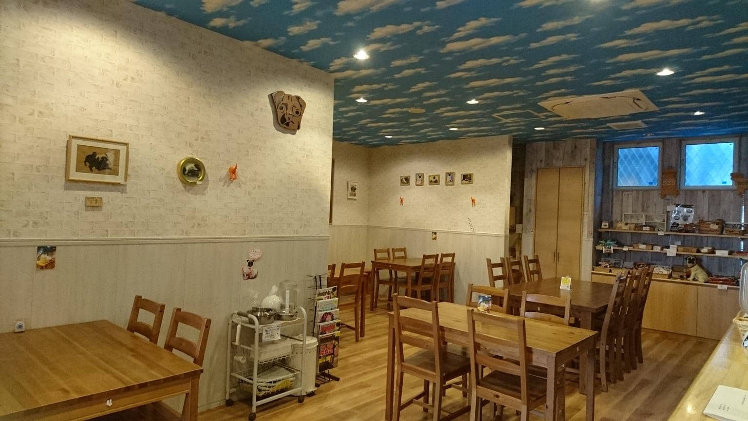 白い壁とウッドのインテリアで落ち着く空間のカフェ店内。