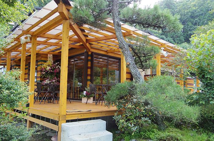 ドッグカフェは雨の日でもゆっくりできる大きなウッド調の建物が特徴。