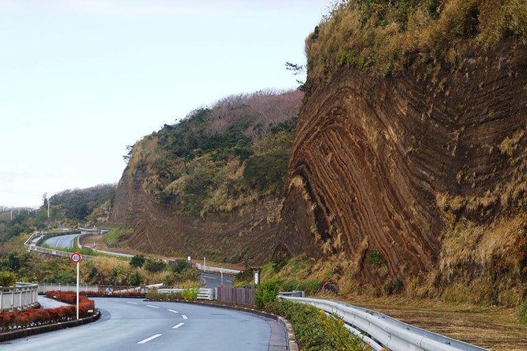 島民から「バームクーヘン」という名で親しまれている「地層大切断面」。三原山の噴火史を物語る地層の断面。100～150年程度に1回という大噴火によって降り積もった堆積物が何層にも重なり美しい縞模様をつくっています