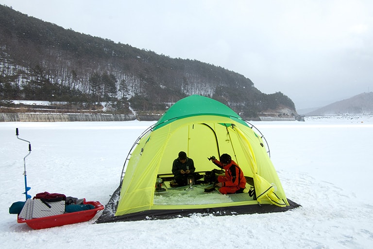 アイスドリルや釣り道具などの荷物一式はソリで運び、小型の魚群探知器を駆使してワカサギの群れを探すのが最新スタイル