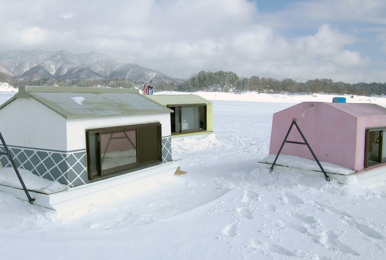 氷上に建つミニ別荘といった感じのワカサギハウスは近年のトレンド。1～2人用の小型から5～6人以上の大型タイプまであり、特に福島県の桧原湖ではポピュラーな存在だ
