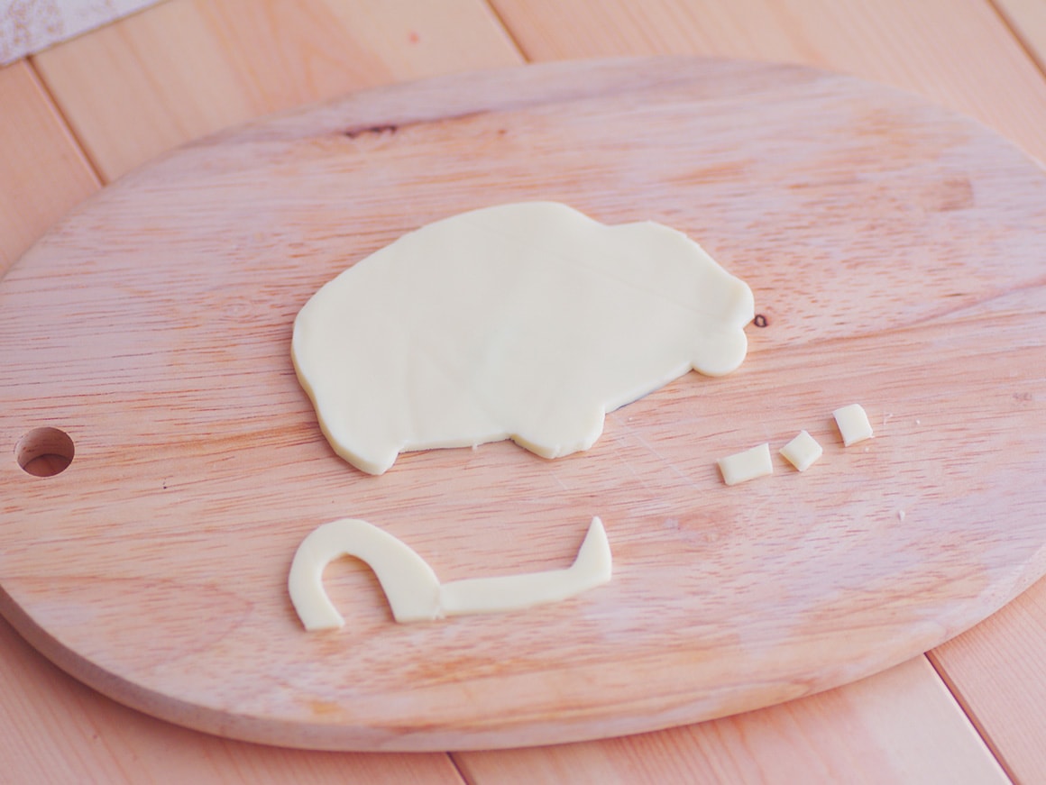 2. 型紙に沿ってつまようじでチーズをカットし、チーズのパーツを作る。