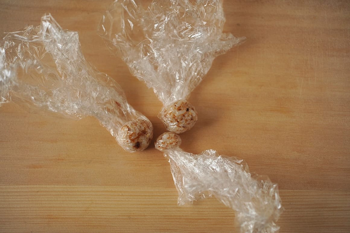 2. 少量のご飯におかかふりかけを混ぜる。ラップで耳と鼻を握る。