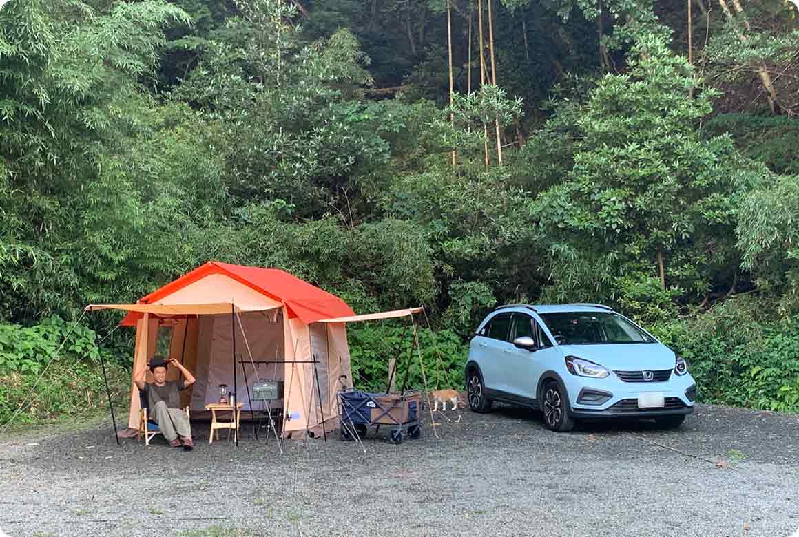 林に包まれた小砂利のオートキャンプサイト