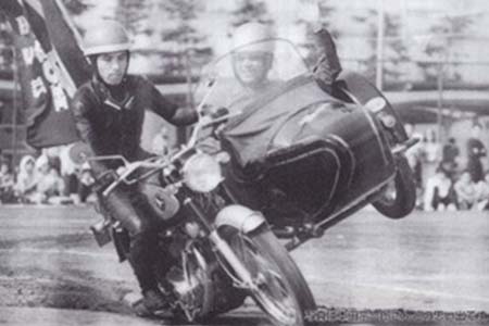 宮田さん（左）が本田宗一郎社長（当時）をサイドカーに乗せてスタントをする様子（研友会の運動会にて／1967年頃、和光研究所のグランド）写真提供：宮田 卓英